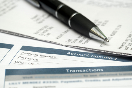 Pen On Top Of Receipts And Bank Statements