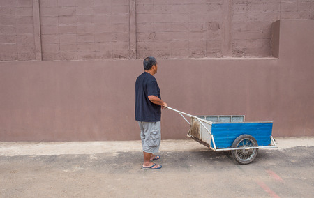 The young man pushes an old cart.の写真素材