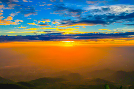 Beautiful landscape nature on mountain with sun cloud fog and bright colors of sky and sunlight during sunsetの写真素材