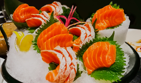 Raw salmon slice or salmon sashimi in Japanese style fresh serve on ice in bowl at Japanese restaurentの写真素材