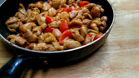 Chicken cooking in a cast-iron frying panの写真素材