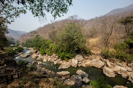 Close up of river stream flowing down over the grey stones. Stock footage. Fast and cold brook with...