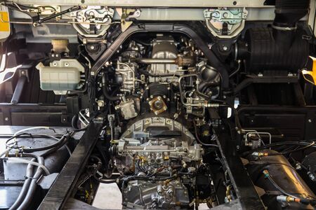 Legendary modern sport engine in car with open hood and raw parts
