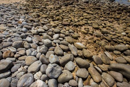 Sea pebbles background. Natural seashore stones textured surface, selective focus, shallow depth of...