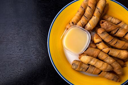 Dried bananas wrapped in flour, fried with oil and fresh milk on a plate are Thai style dessertsの写真素材