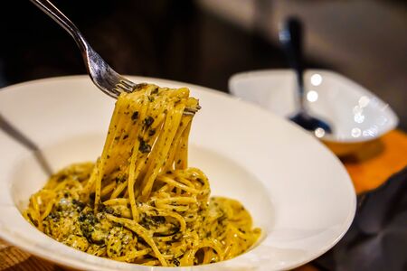 ladling pasta carbonara, spaghetti or spaghetti carbonara
