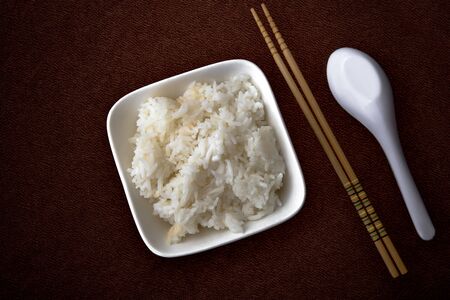 Jasmine rice cooked in a cup placed on a wooden table in the backgroundの写真素材
