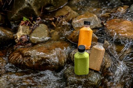 Orange milk tea, green tea and chocolate in plastic bottles delivered to the house that are placed in the waterの写真素材