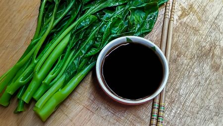 Chinese kale vegetable raw material green food and Fried photo on wood desk backgroundの写真素材