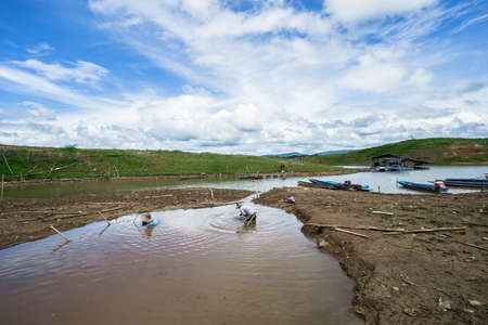 Fishermen are catching fish in a small, rural pond.