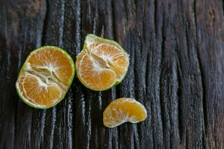 fresh ripe juicy yellow mandarin ( clementine, tangerine ) on wooden rustic vintage table with leaf. Tangerines citrus fruit background conceptの写真素材