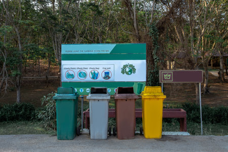 Trash bin located in the public park. Three containers of different colors for collecting different types of garbage are on the ground in public garden, Concept environmental stewardshipの写真素材