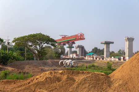 Large machinery and cement columns in the construction of rural roads in Thailand