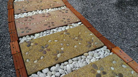 Square cement slabs are arranged to serve as a path in the garden of the houseの写真素材