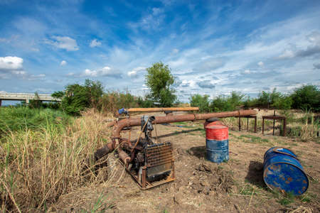 The pump is pumping from the canal to the other side of the farm. Farmers pump water for farming.の写真素材