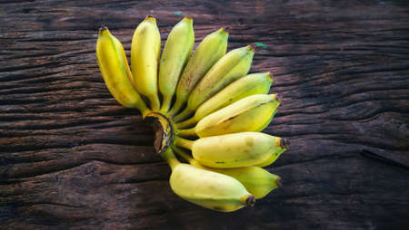Yellow cultivated banana Ripe cultivated banana call Kluai Nam Wa in Thai on woodの写真素材