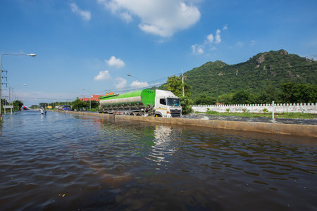 20,Sep,2021,Lopburi Thailand, Cars driving down a flooded street during the worst flooding in decades in Thailandのeditorial素材