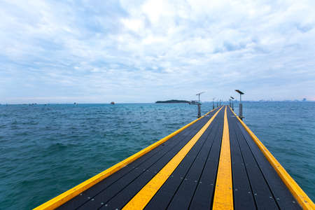 The perspective view of Sribanphe jetty in Rayong Province, Thailand, with the sea, white cloud and blue sky is in the backgroundの写真素材