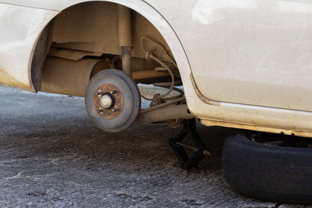 Replacement wheels on the highway, the car is jacked, the wheel is removed, there is a spare wheelの写真素材