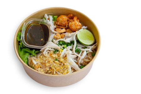 Dry chicken noodles served with sweet sauce and green vegetables, a Thailand street food.