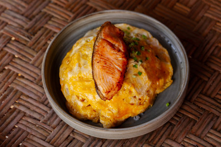 Omelet rice served with fried salmon on topの写真素材