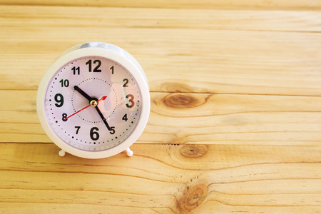 Alarm clockon wooden backgroundの写真素材