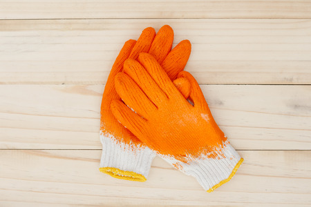 Orange gloves on wood background