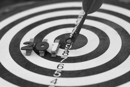 Old dart target with arrow on wooden alphabet 2018 new year concept. black and white picture.の写真素材