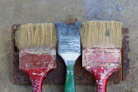 Old paint brushes on wall background, top viewの写真素材