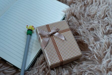 Gift box with a  ribbon and a Brown bow on a Wool carpet background. Selective focus.