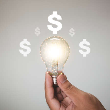 Hand holding a light bulb with increasing for business growth and profit increase concept.の写真素材