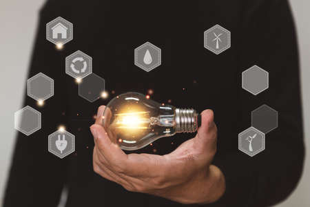Hand holding light bulb. idea with environment and innovation . innovative technology and solution creative business design concept.の写真素材