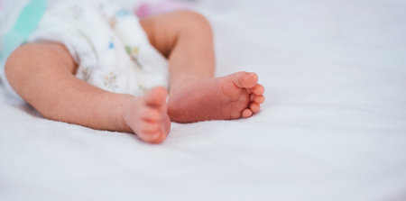 Newborn baby feet on white blanket. Cmaternity and babyhood concept.の写真素材