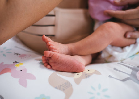 Newborn baby feet on white blanket. mother hold feets of newborn baby. Cmaternity and babyhood...
