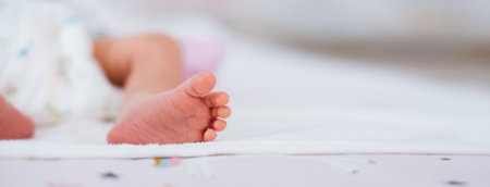 Newborn baby feet on white blanket. Cmaternity and babyhood concept.