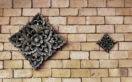 Pattern of flower carved wood on Brick wallの写真素材
