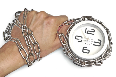 A hand chained with a clock の写真素材