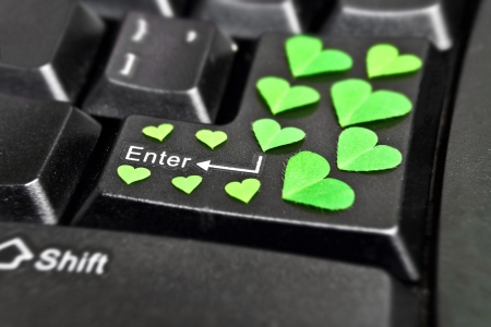 computer keyboard covered with green heart shape leavesの写真素材