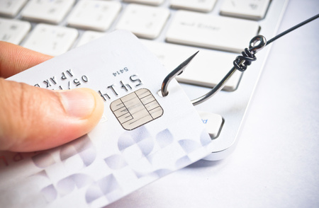 phishing - fish hook with a credit card on white computer keyboard