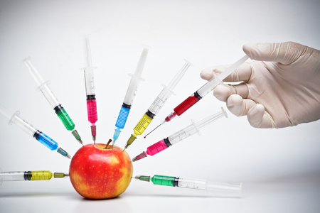hand injecting chemical to apple - gmo fruitの写真素材