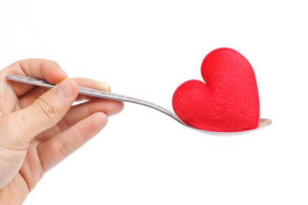 hand holding a spoon with a red heartの写真素材