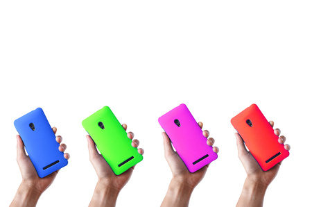 hands holding colorful smartphones on isolated backgroundの写真素材