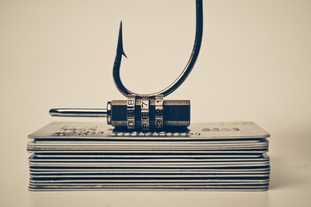Phishing  A big fish hook on a pile of credit cardsの写真素材