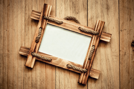 wooden picture frame on old wood plank wall backgroundの写真素材
