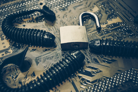 computer security breach due to worm attack - worm on computer circuit board with open security lockの写真素材