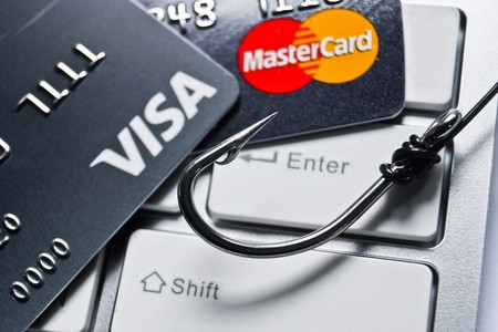 Close up of VISA and Mastercard credit card on white computer keyboard with a fish hookのeditorial素材