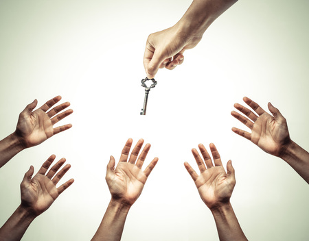 hand giving a key to many hands - giving help, opportunity, success concept