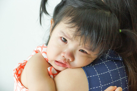 Asian baby girl hugging her mother cryingの写真素材