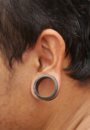 pierced ear with big ringの写真素材