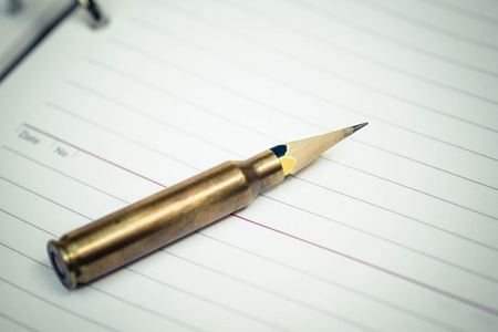 A rifle bullet with a pencil at the head / Using idea as weapon conceptの写真素材